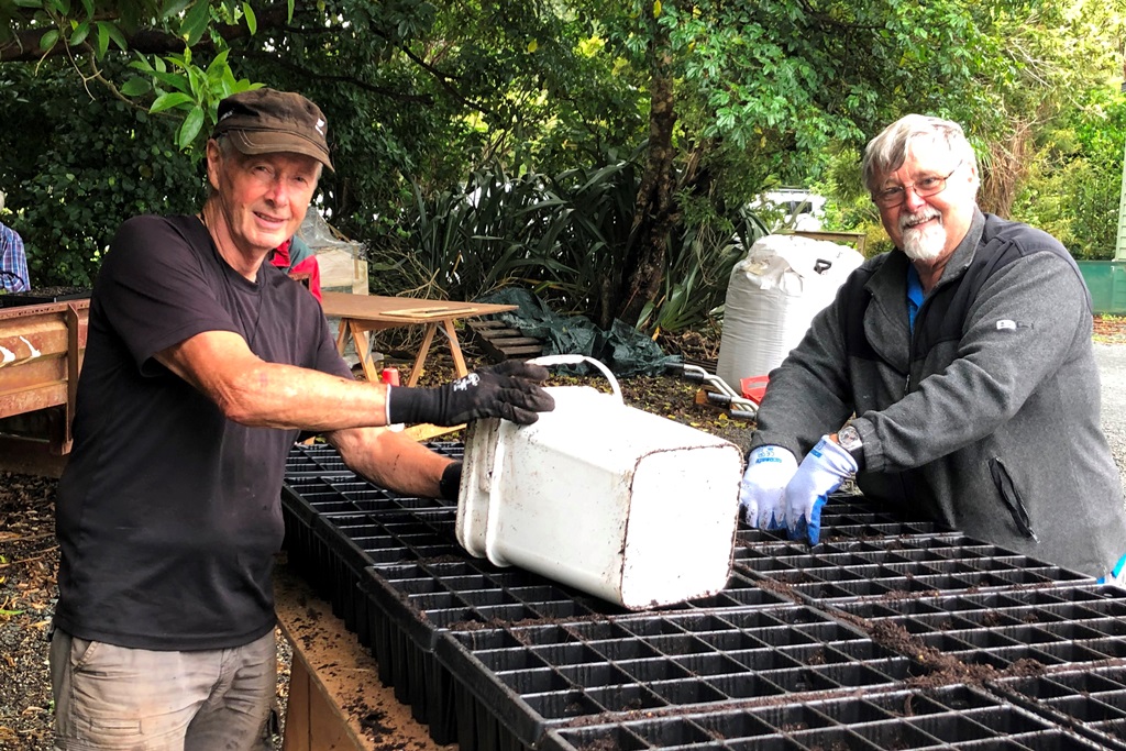 Two men with seedling trays
