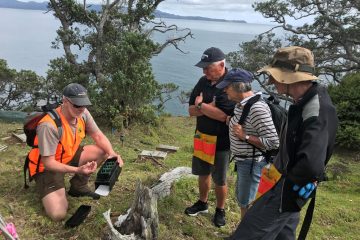 People looking at tracking tools at seabird nesting area.