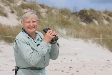 Woman at beach with binolculars